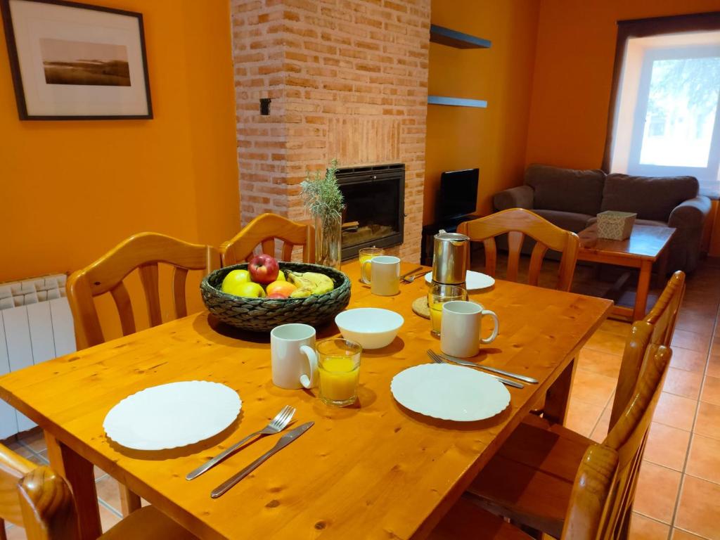 a wooden table with a bowl of fruit on it at Alojamiento Antigua Casa de Telefonos in El Berrueco