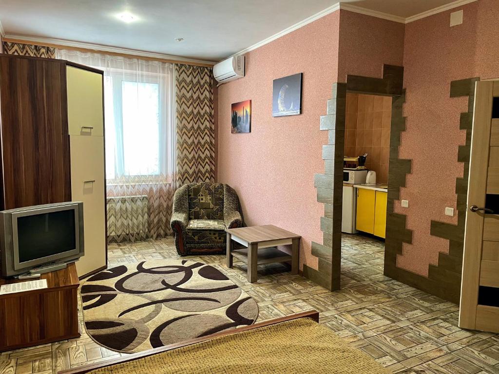 a living room with a tv and a couch and a table at Апартаменты в центре Кривого Рога in Kryvyi Rih