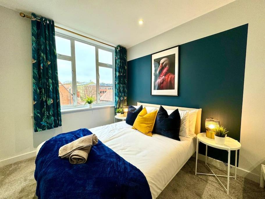 1 dormitorio con 1 cama grande y paredes azules en Bournemouth Bliss: 3Bedroom Near Sea & Town Vibes!, en Bournemouth