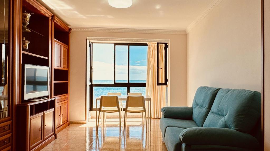 - un salon avec un canapé et une table avec des chaises dans l'établissement Click&Guest - Bright Sun House with Sea Views, à Agüimes