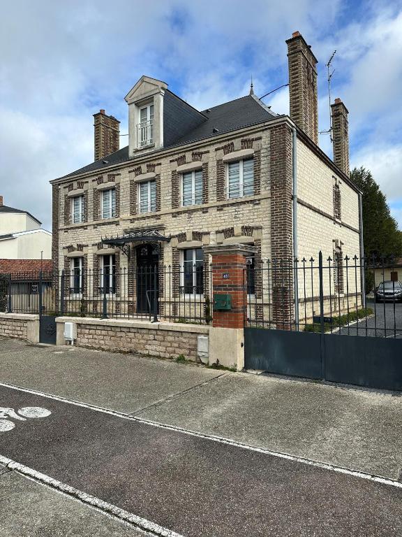 a large brick house with a fence in front of it at Bel appartement / Troyes in Saint-Parres-aux-Tertres