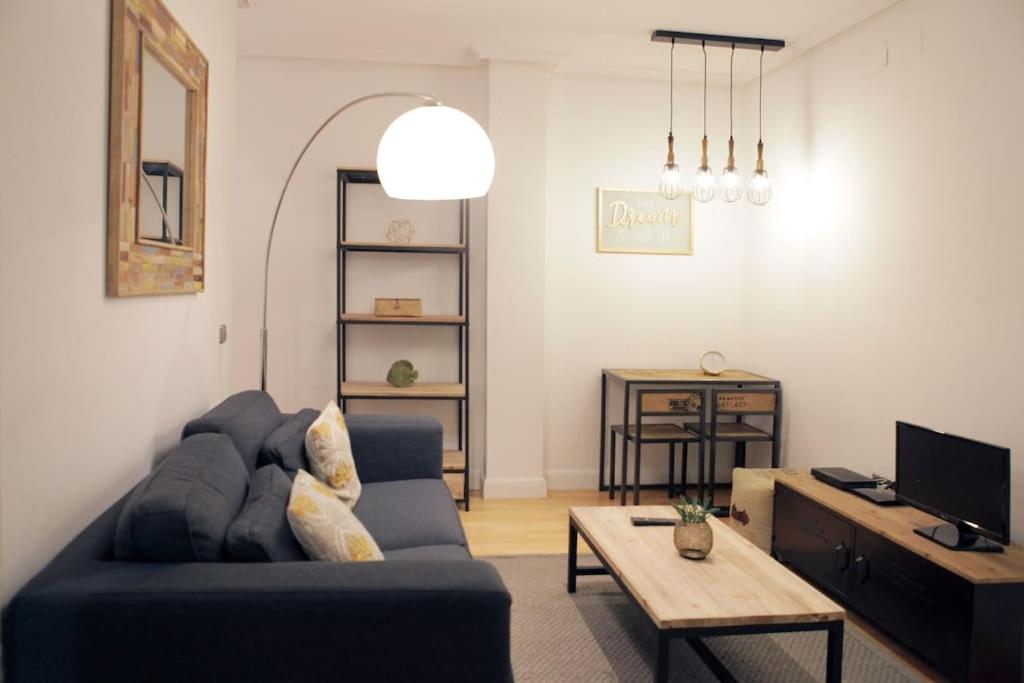 sala de estar con sofá azul y mesa en Cozy 2 bedrooms apartment in Chamberi (A.M), en Madrid