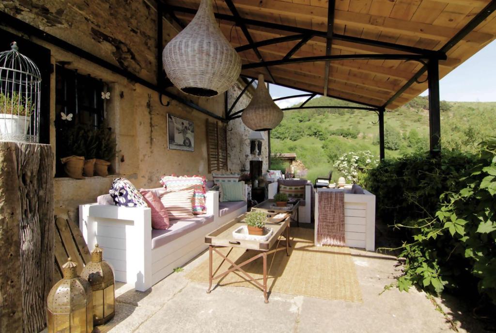 eine Terrasse mit einem weißen Sofa und einem Tisch in der Unterkunft Le château brangoly in Enveitg