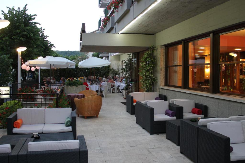 ein Restaurant mit Sofas und Tischen und Personen, die an Tischen sitzen in der Unterkunft Albergo Rossana in Chianciano Terme