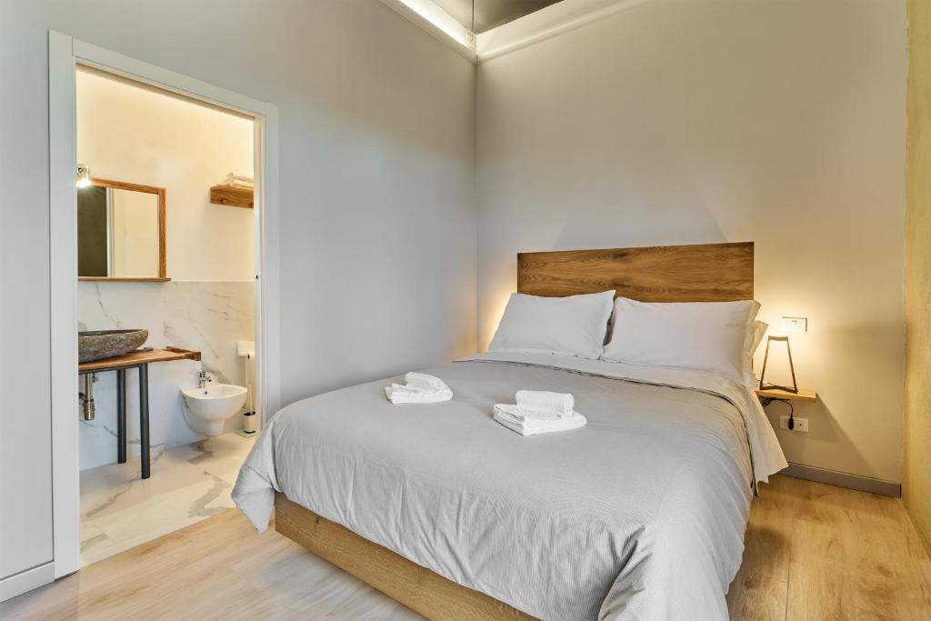 a bedroom with a bed with two towels on it at La Dama Country Rooms in Monteriggioni