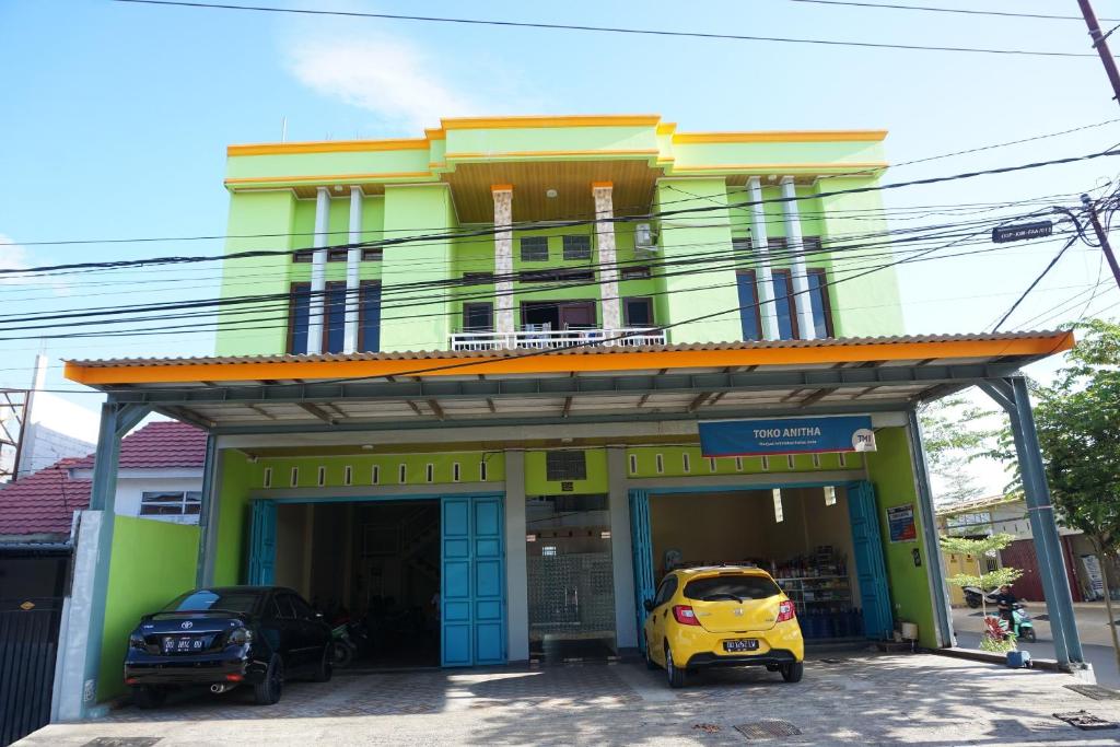 a yellow car parked in front of a building at OYO 93877 Atifah Homes in Sungguminasa