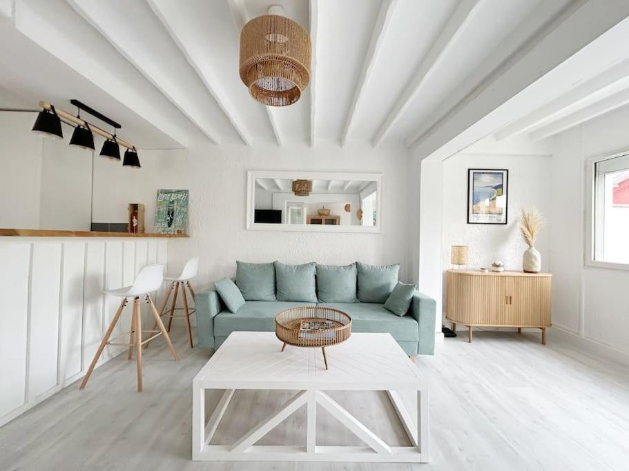 un salon avec un canapé bleu et une table dans l'établissement Charmante maison pour 6 personnes, à La Teste-de-Buch