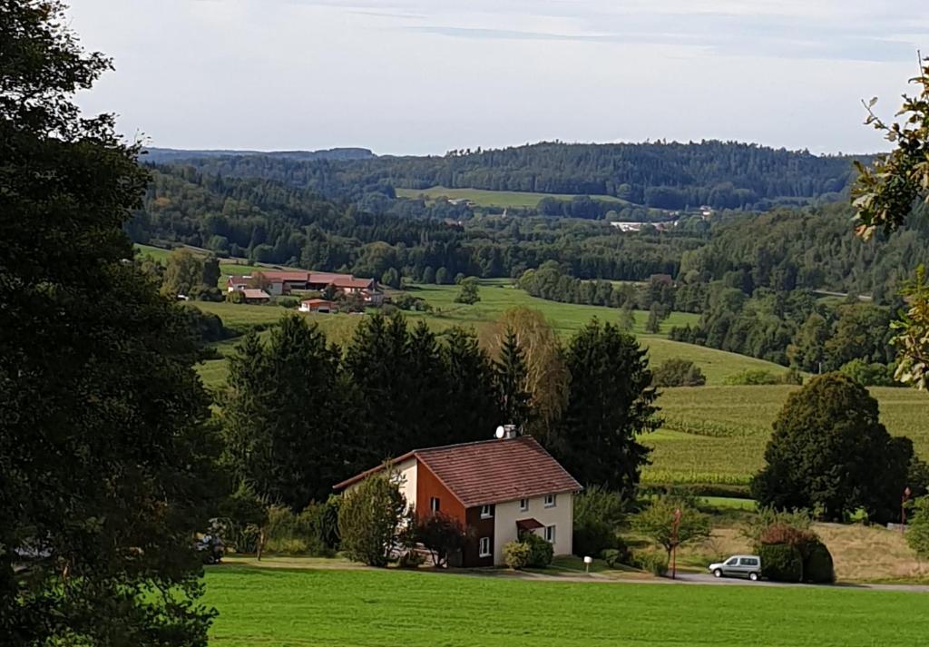 a house in the middle of a green field at La Vision en Vosges in Xamontarupt