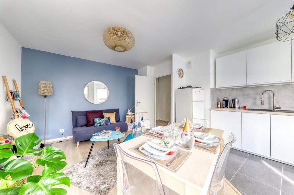 een keuken en een woonkamer met een tafel en een bank bij C4 Les Jardins d'Orsonville in Chessy