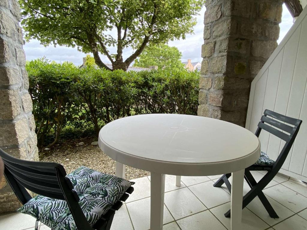 uma mesa branca e 2 cadeiras num pátio em Ref 006 - Appartement 2 pièces à deux pas de la plage et du port, à louer pour les vacances em Arzon