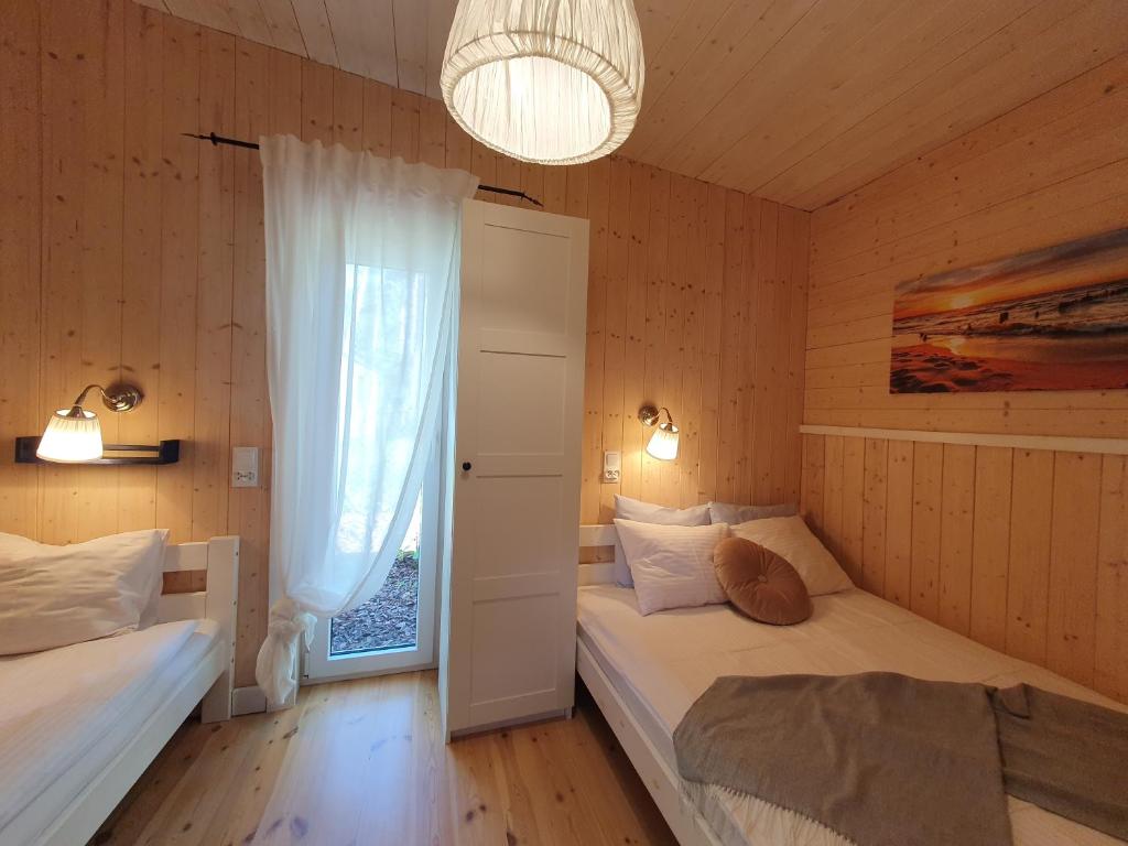 a bedroom with two beds and a window at Patio Dębki in Dębki