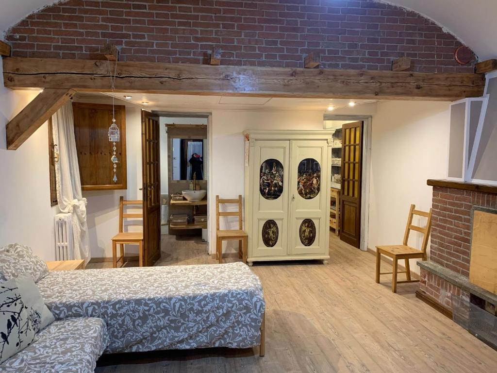 uma sala de estar com uma cama e uma parede de tijolos em CasArte: monolocale TERRA em Alpignano