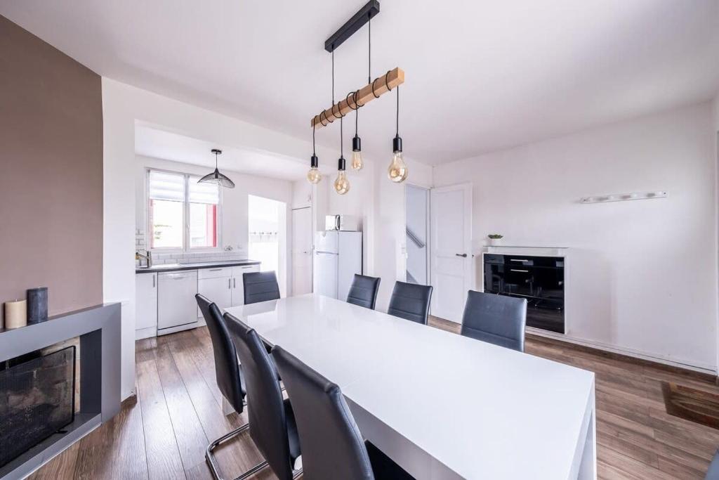 uma cozinha e sala de jantar com uma mesa branca e cadeiras em House Disney Village em Dammartin-sur-Tigeaux