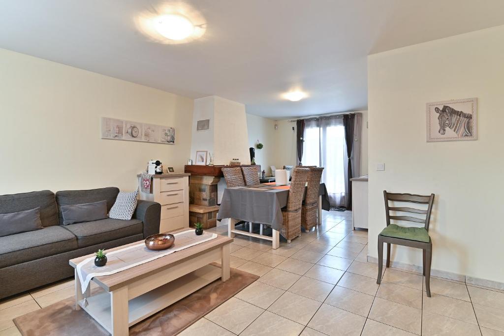 een woonkamer met een bank en een tafel bij La Meldoise - Maison pour 5 voyageurs in Meaux