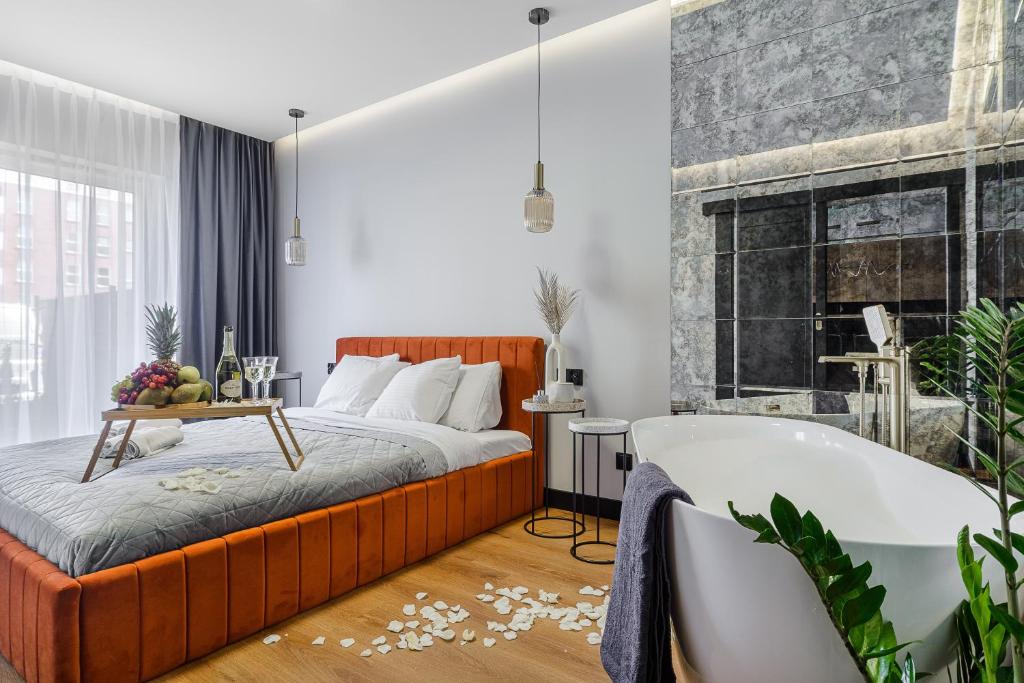 Lumina premium apartments with balcony, parking في لودز: غرفة نوم مع سرير وحوض استحمام