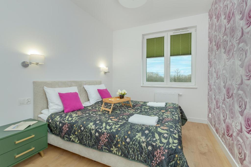 a bedroom with a bed with a table and a window at Przy Plaży - Rodzinny Apartament z Salą Zabaw Puck by Renters in Puck