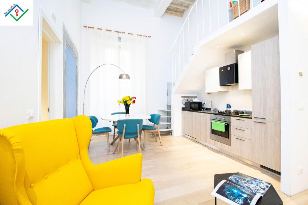 ein Wohnzimmer mit einem gelben Sofa und einem Tisch in der Unterkunft Little Venice Apartment in Livorno