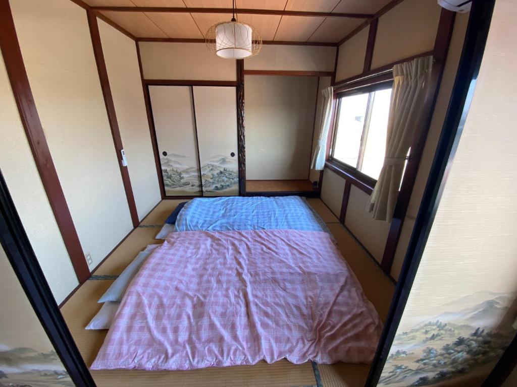 Postel nebo postele na pokoji v ubytování ゲストハウスすまいるさん