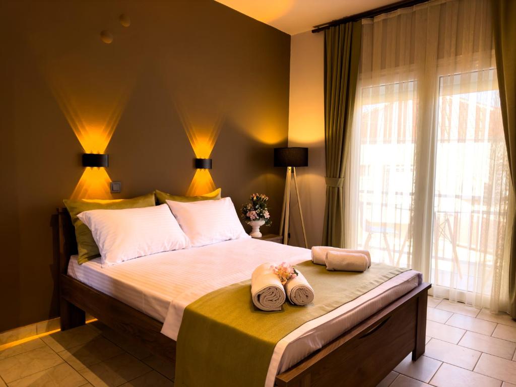 a bedroom with a bed with two towels on it at Ten Number Suites in Limenas