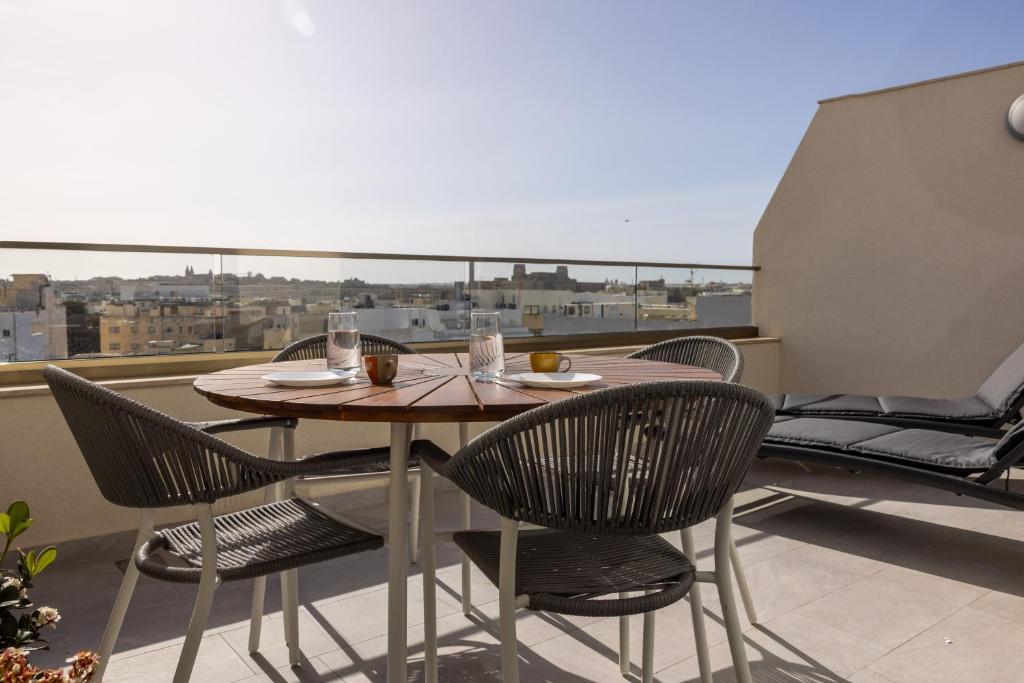 uma mesa e cadeiras numa varanda com vista em Penthouse With Sunny Terrace em Msida
