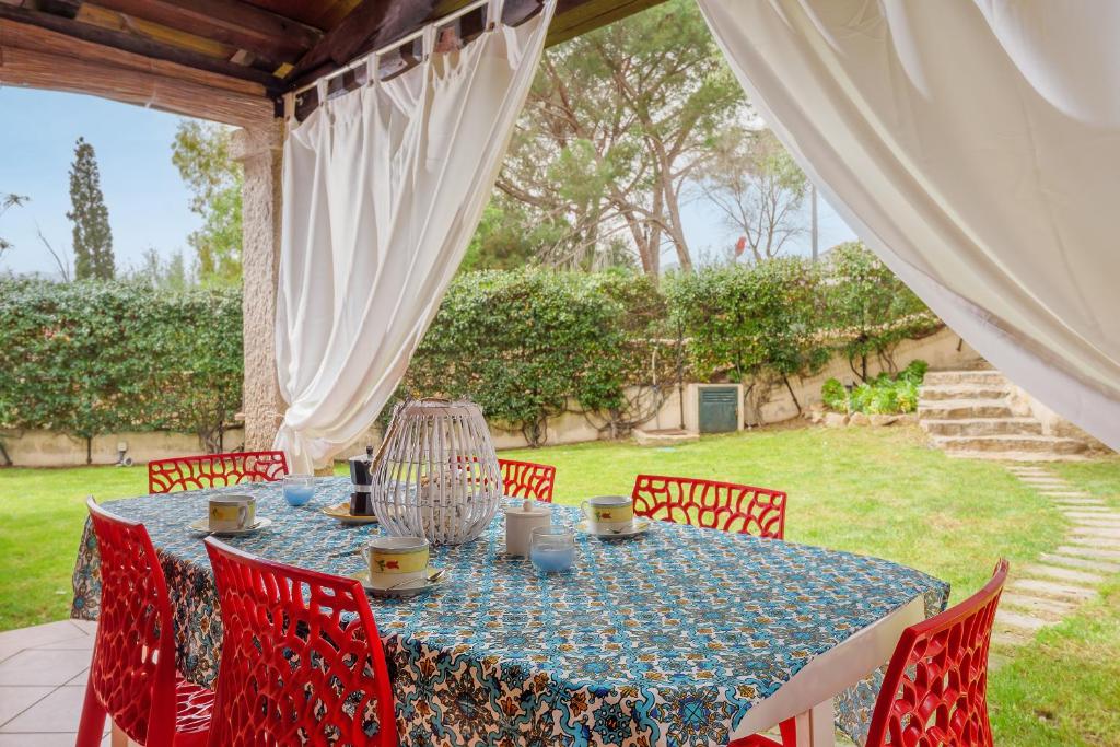 a table with red chairs and a blue table cloth at Villa Quattro Cuori in San Teodoro