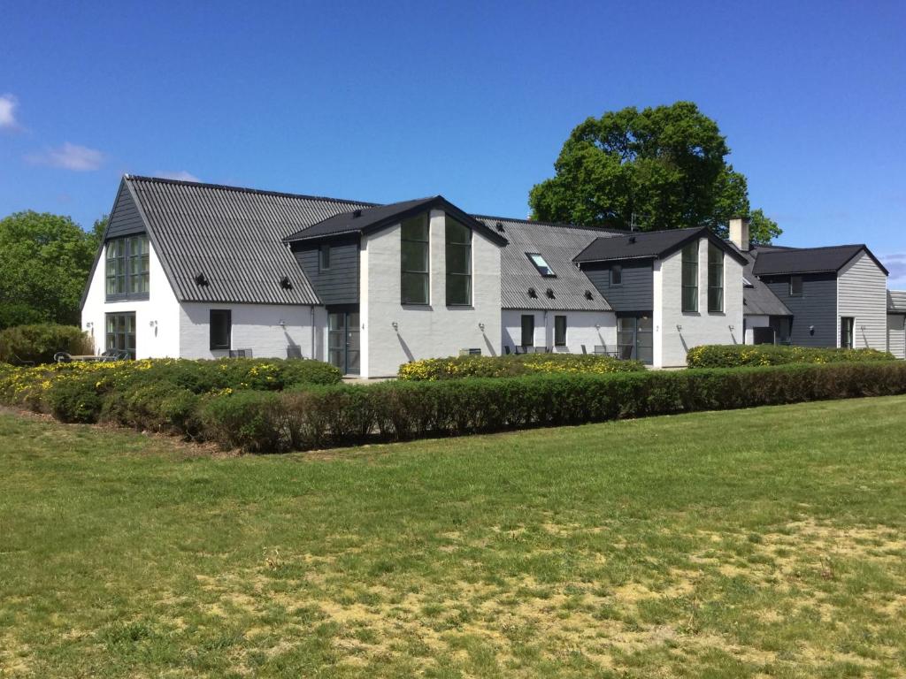 una gran casa blanca con techos negros en 2 voksne + 2 børn en Læsø