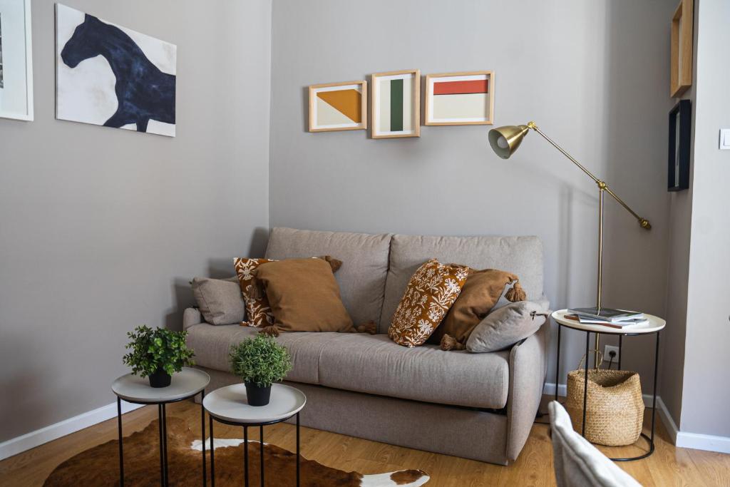 a living room with a couch and two tables at Impar Triplex House in Porto