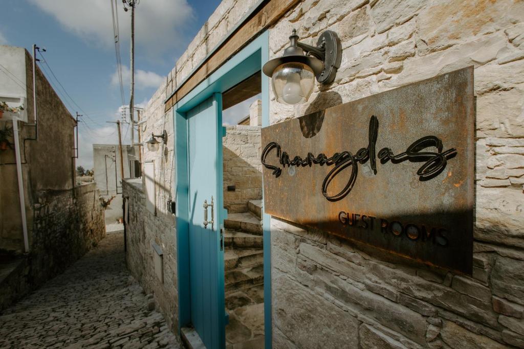 ein Schild an der Seite eines Gebäudes mit blauer Tür in der Unterkunft Smaragda's Guest Rooms in Limassol