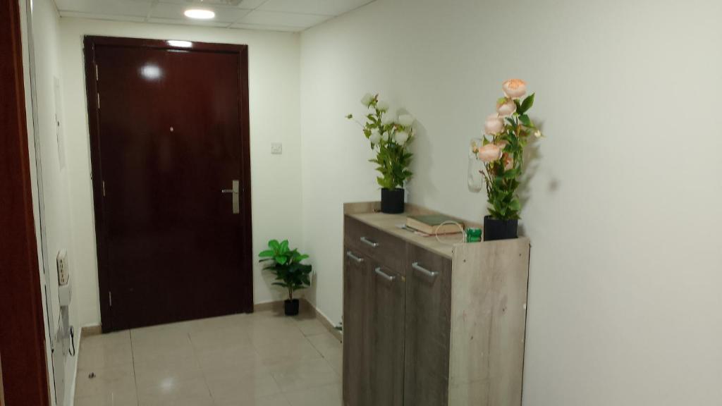 a room with a wooden cabinet with flowers on it at Corniche ajman 2 in Ajman 