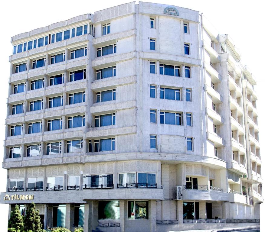 a tall white building with a sign on it at Hotel Tilmen in Gaziantep