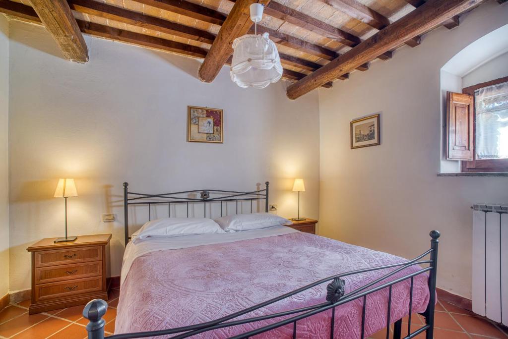um quarto com uma cama e duas mesas de cabeceira e dois candeeiros em Lavanda ad Antico Casale '700 em Umbertide