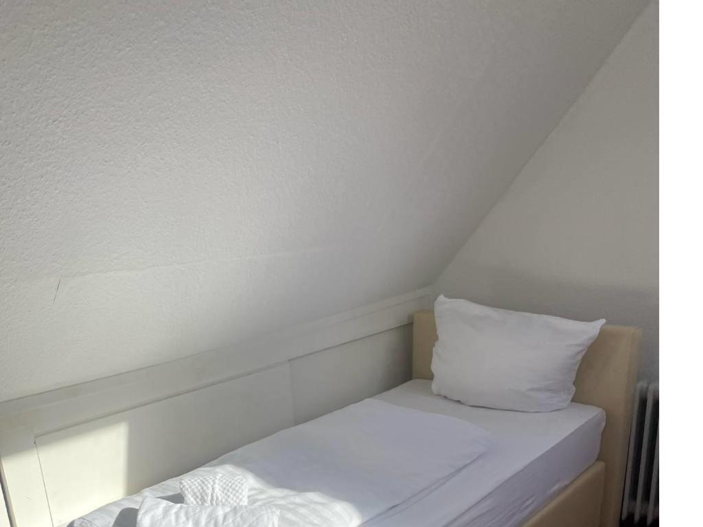 a white bed with a pillow on top of it at Room in Guest room - Pension Forelle - double room n01 in Forbach