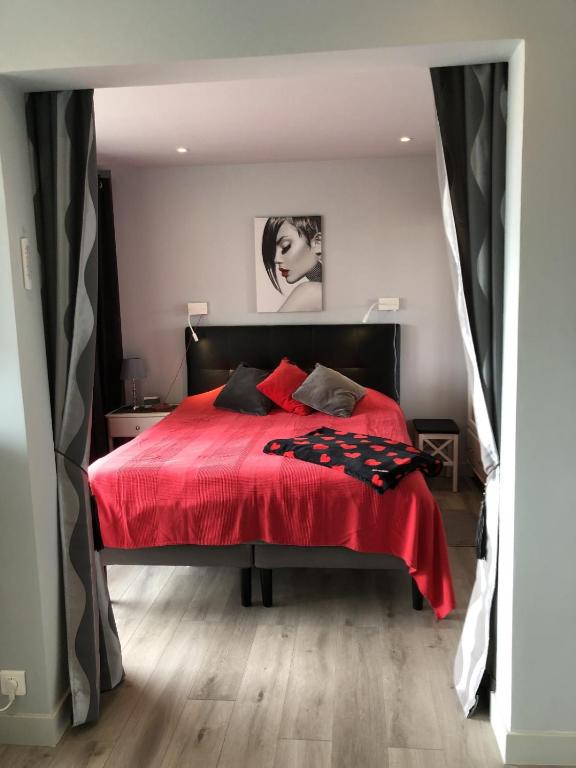 - une chambre avec un lit rouge et une couverture rouge dans l'établissement Naturiste Cap d'Agde Héliopolis F 31, au Cap d'Agde