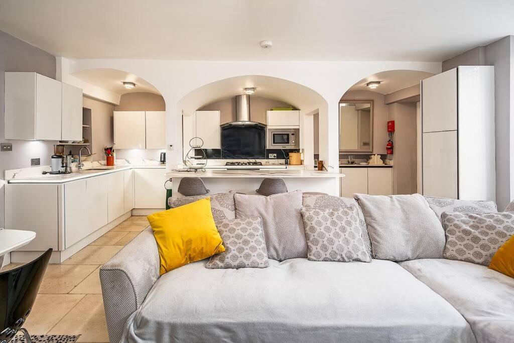 uma sala de estar com um sofá e uma cozinha em Beautiful Basement Apartment em Bath