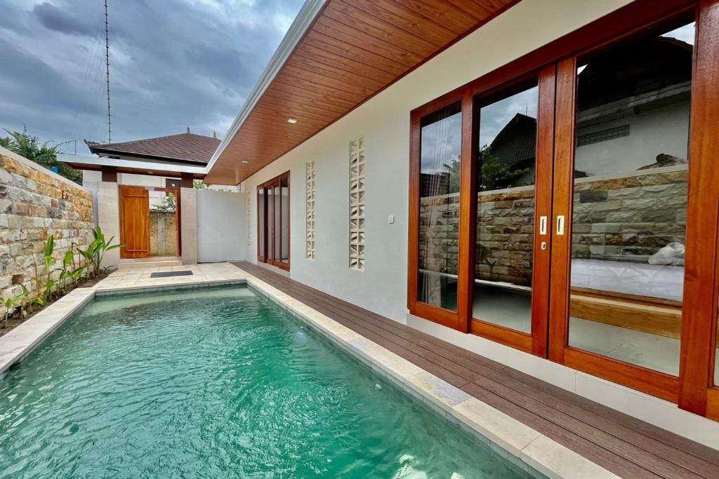 a swimming pool in front of a house at Belvilla 93824 Villa Nesa Near Titi Batu Club Ubud in Ubud