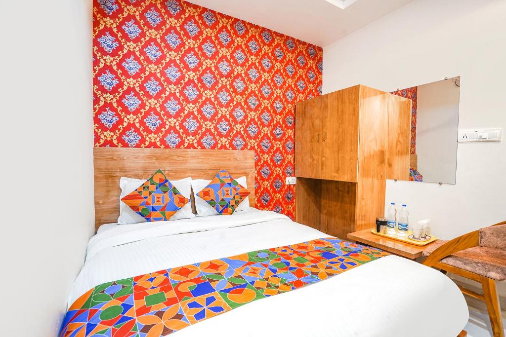 - une chambre avec un lit et un mur rouge dans l'établissement FabHotel Prime Lotus, à Vadodara