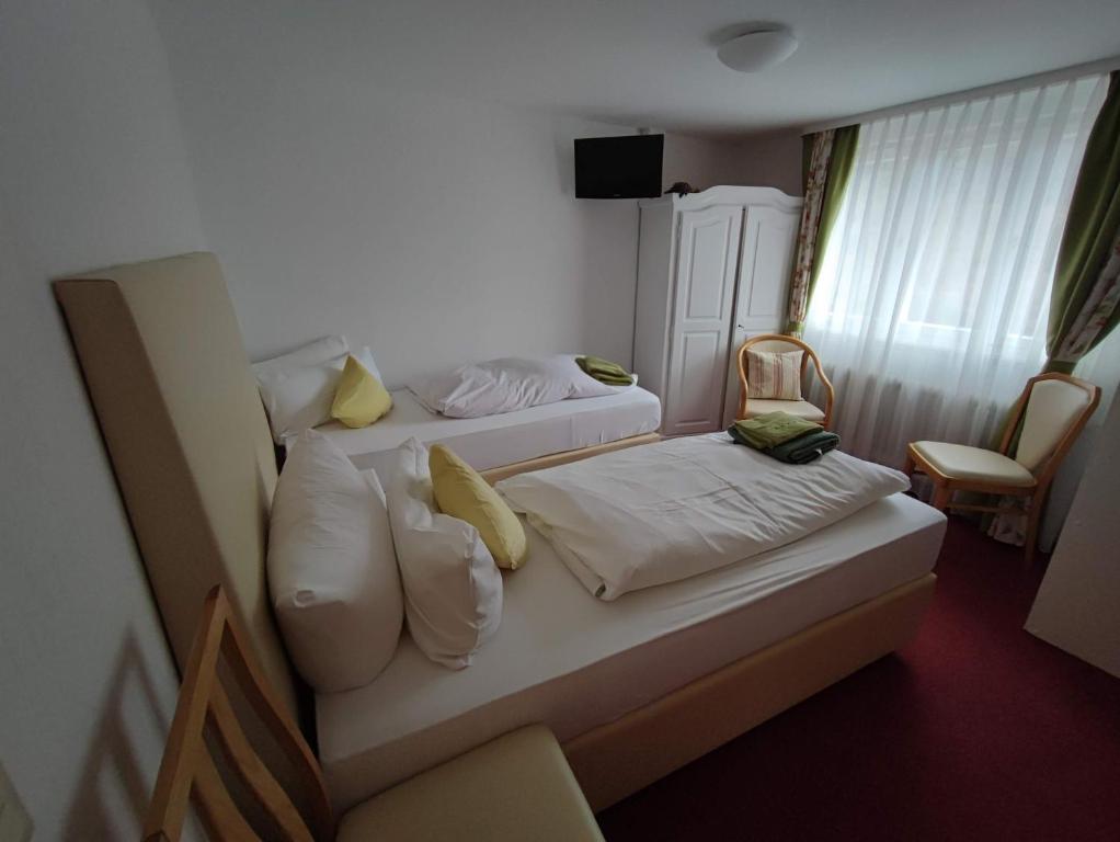 a hotel room with two beds with yellow pillows at Room in Guest room - Pension Forelle - double room 01 in Forbach