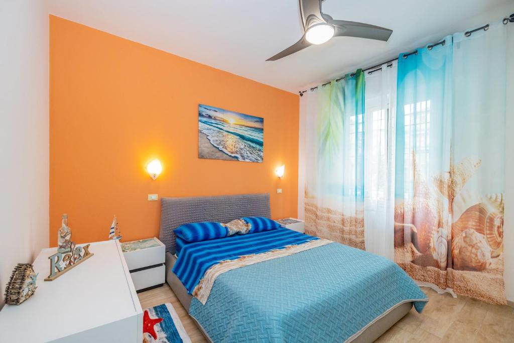 a bedroom with a blue bed and orange walls at Mare sole mountain bike -citra 0328 in Finale Ligure