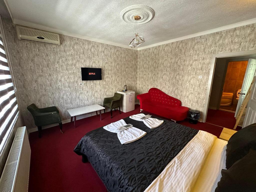 a hotel room with a bed and a red couch at ENJOY HOUSE BOUTİQE OTEL in Ankara