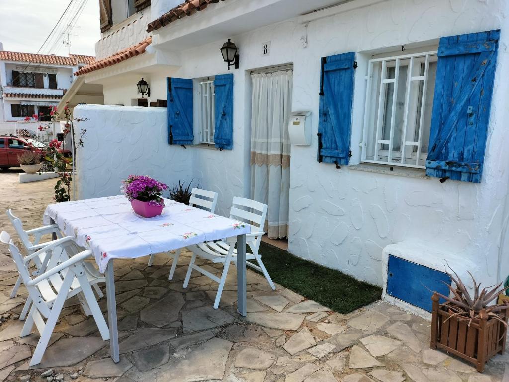 una mesa blanca y sillas frente a una casa blanca en CASA MARINERA ALCOSSEBRE en Alcocéber