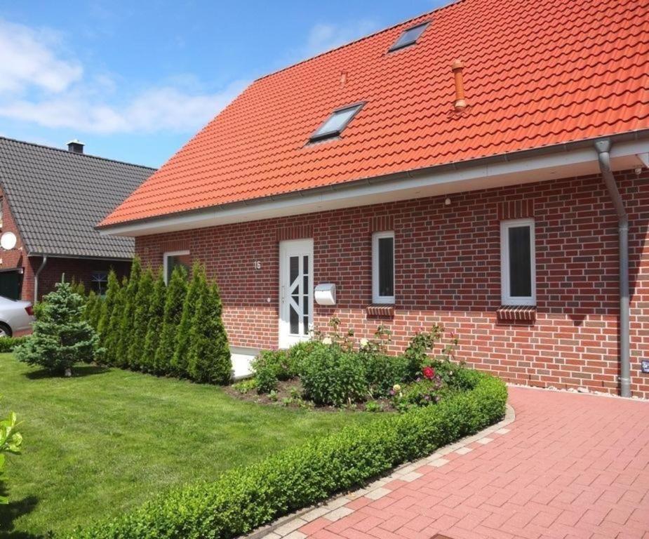 een stenen huis met een oranje dak bij Appartement in Burg Auf Fehmarn mit Terrasse, Garten und Grill in Fehmarn