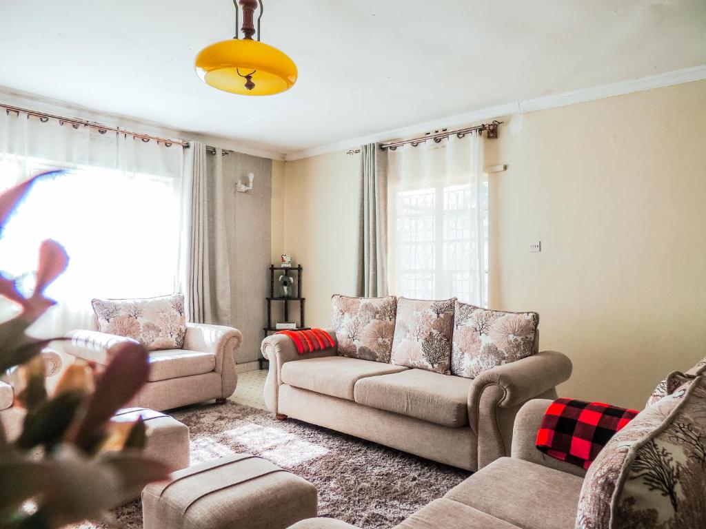a living room with two couches and a window at 3BR Serene Bungalow in Lower Kabete in Nairobi
