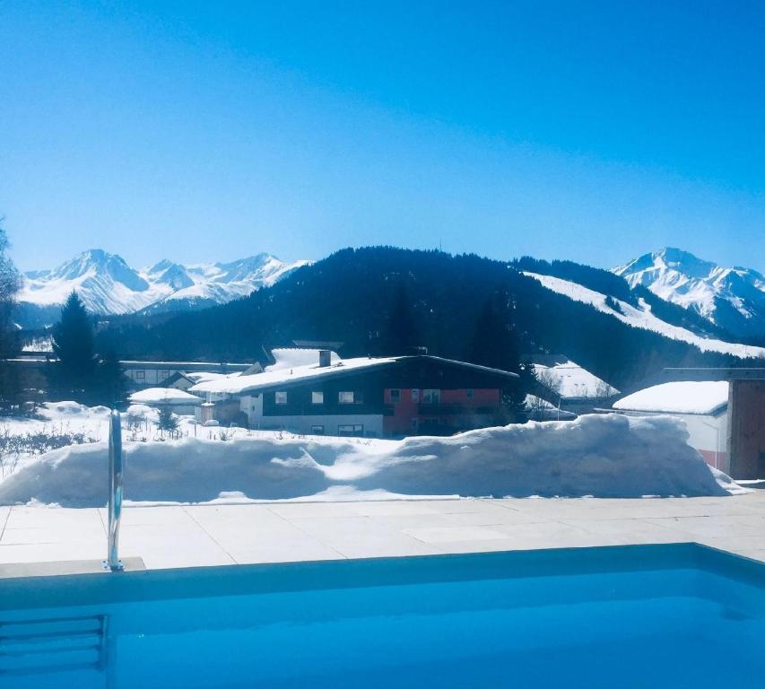 Ferienhaus in Seefeld In Tirol mit Großer Terrasse في سيفيلد ان تيرول: سلسلة جبلية مغطاة بالثلوج مع منزل في المقدمة