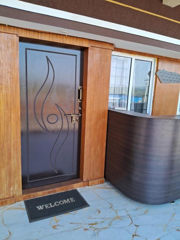 a door to a building with a welcome sign on it at Royal homes a1 in Kushālnagar
