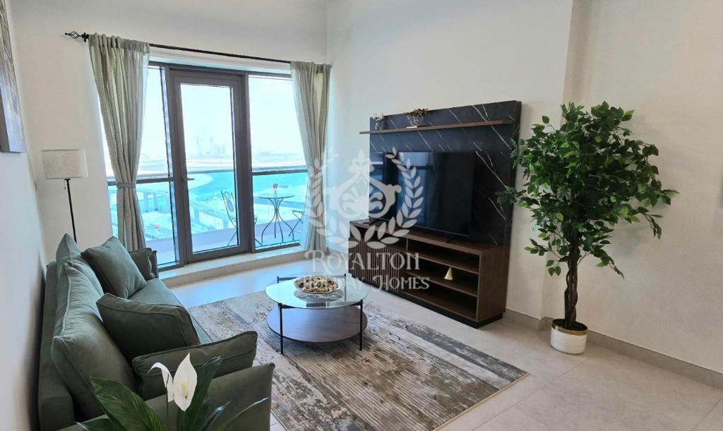 ein Wohnzimmer mit einem Sofa und einem TV in der Unterkunft Royalton - Vibrant Cityscape 1BR Next to Business Bay Canal in Dubai