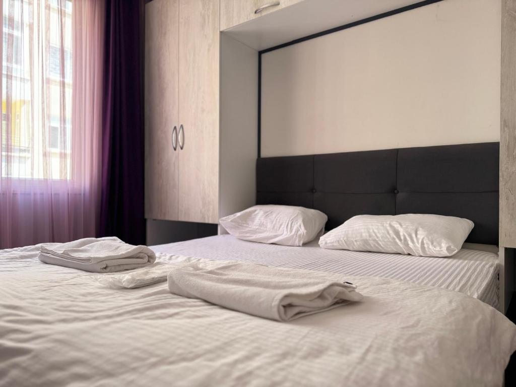 a bed with two white towels on top of it at palmiye butik otel in Mezitli