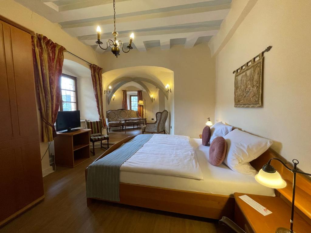 een slaapkamer met een groot bed en een woonkamer bij Hotel Schloss Zell in Zell an der Mosel