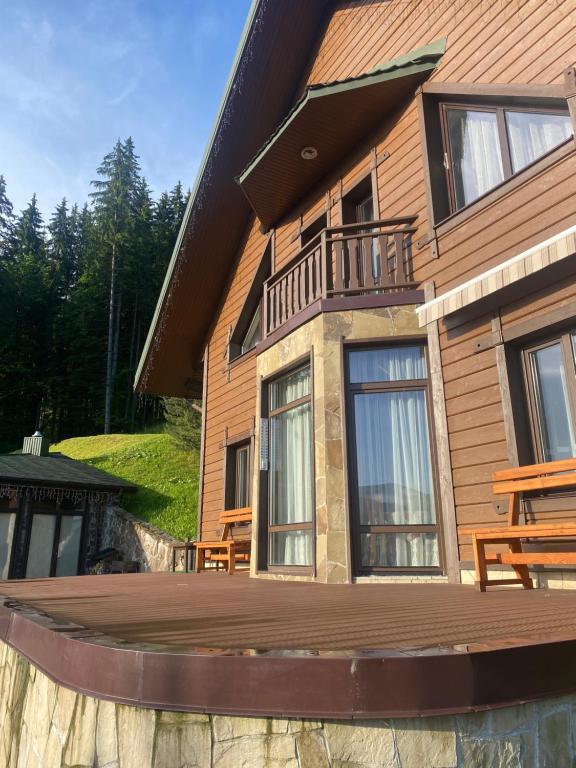 a house with a wooden deck in front of it at Shale Anemona in Bukovel