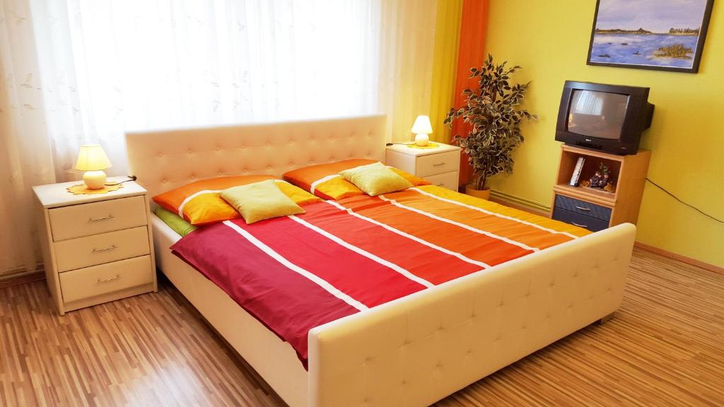 1 dormitorio con 1 cama grande y TV en Gästezimmer Wurm, en Mönchhof