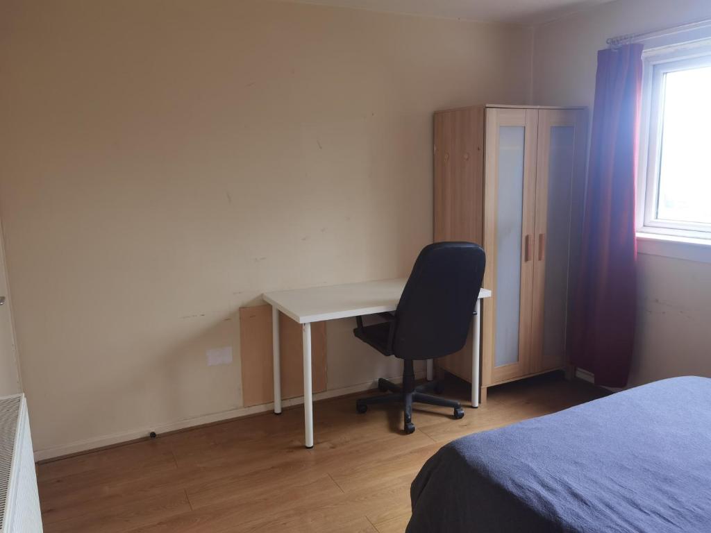 a bedroom with a desk and a chair and a window at Glasgow Double Room Free Parking in Glasgow